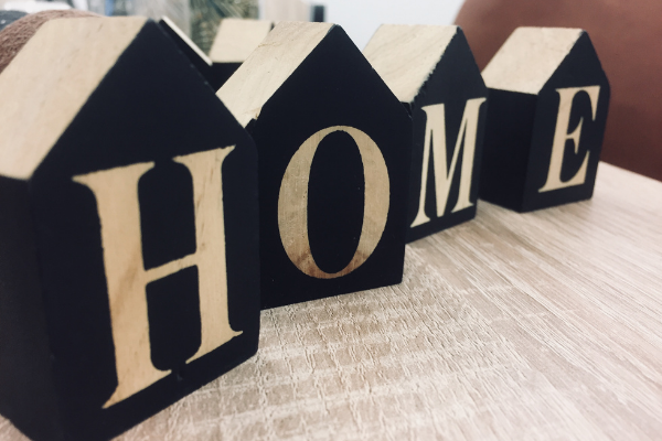Four decorative wood boxes with each letter of the word HOME written on each box