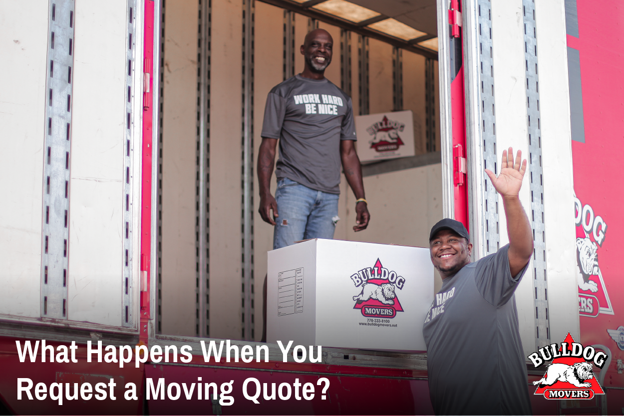 Two Bulldog Movers employees smiling and waving moving boxes from the large red Bulldog Movers moving truck