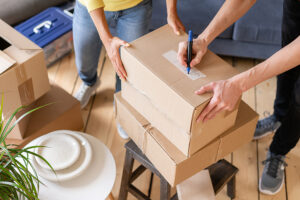 People packing and labeling a moving box